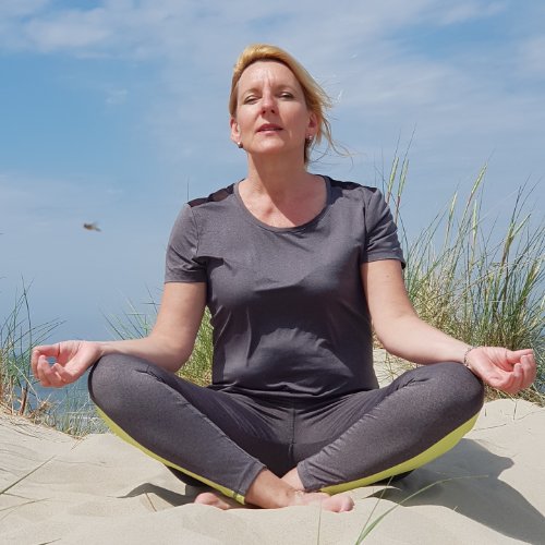 Helga mediteert op een duin op Vlieland tijdens workation